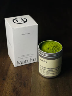 Matchu Matcha powder in a canister with packaging on a wooden surface 100g