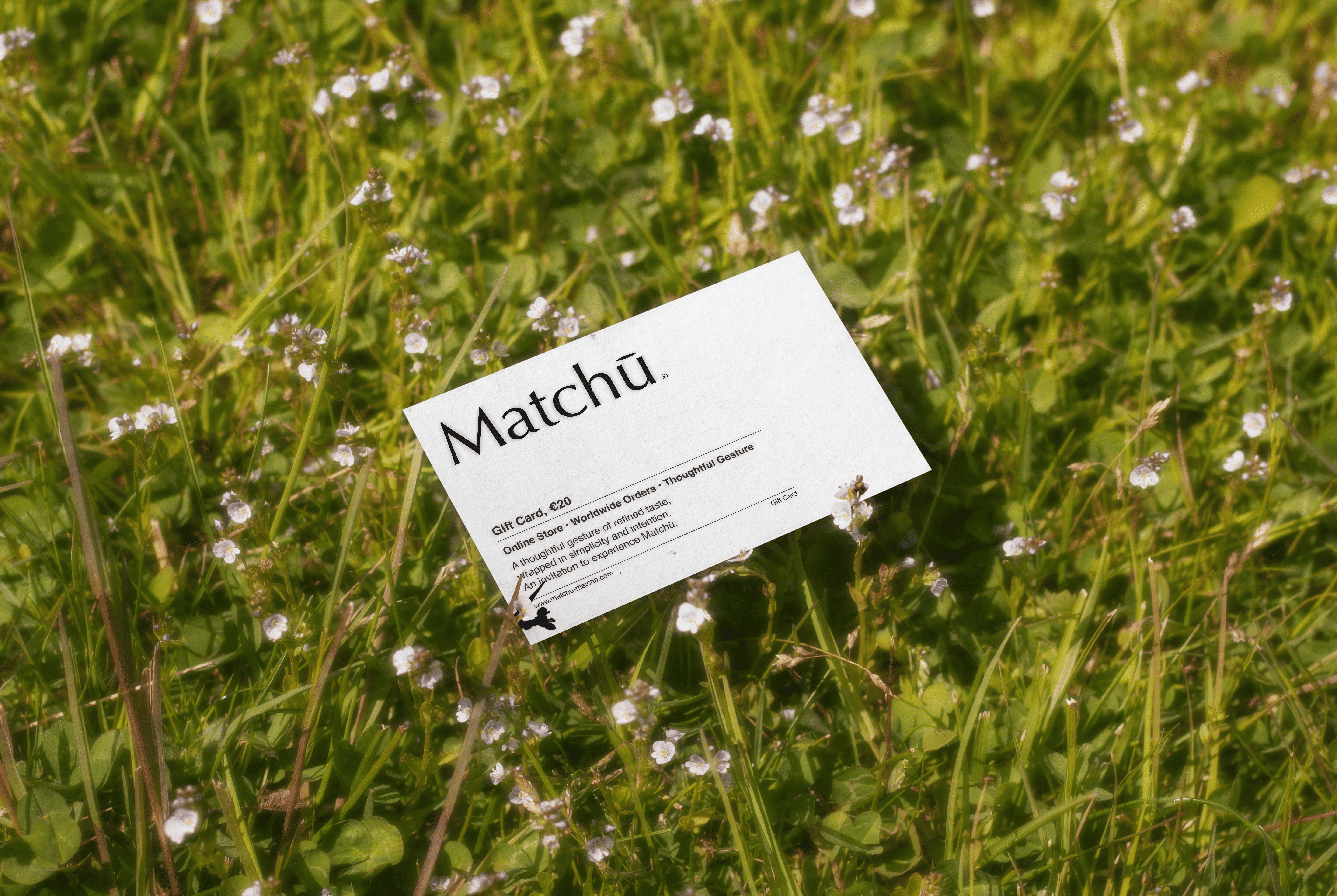 photo showing a Matchu Matcha Gift Card laying in green grass.